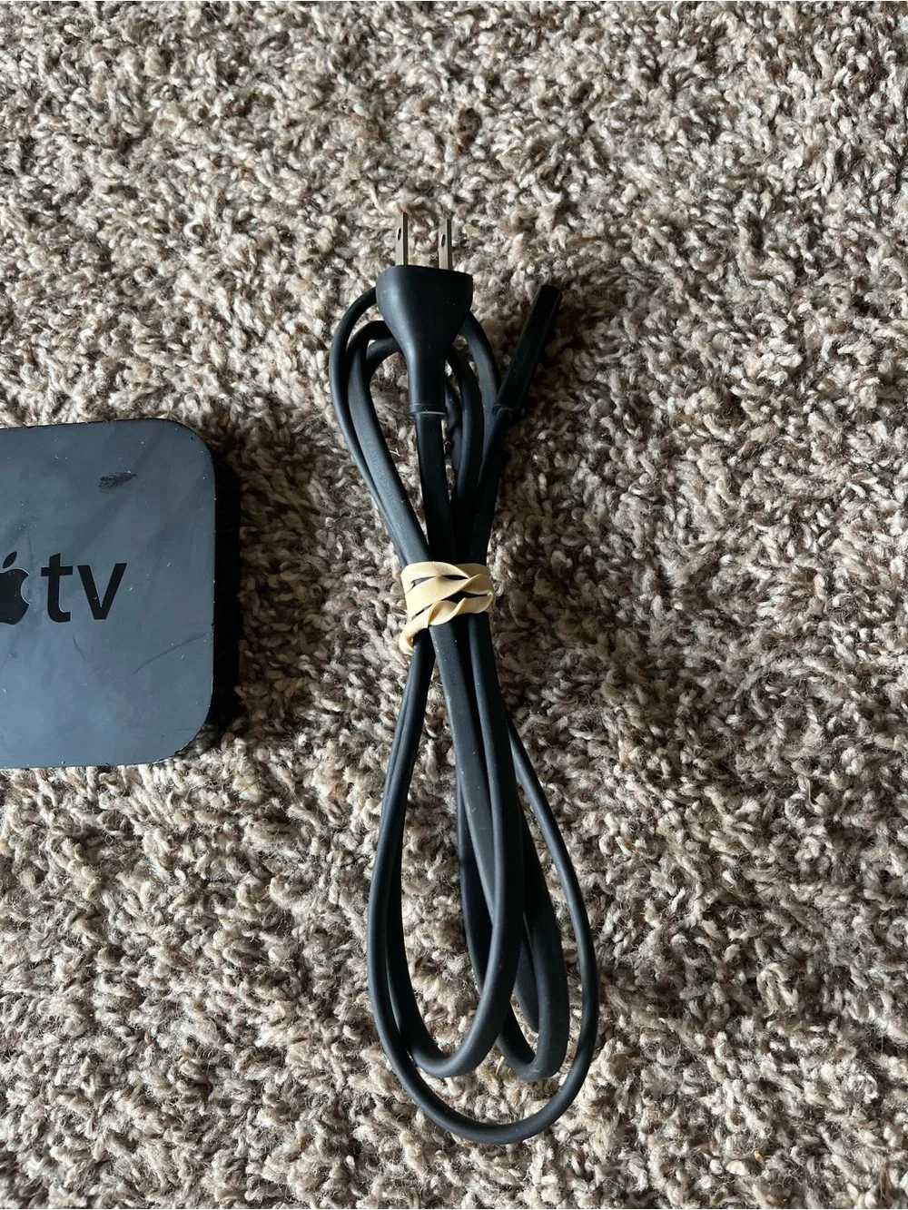 Apple TV with Silver Remote and Black Power Cable